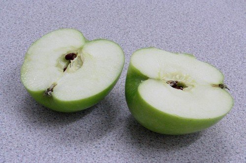 Половинка яблоко зеленое на белом фоне
